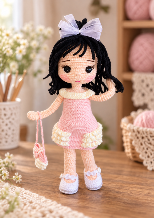 Asel Doll crochet pattern with black yarn hair, white bow, pink dress, shoes, and handbag